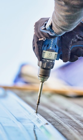 a person using a drill to drill a piece of wood