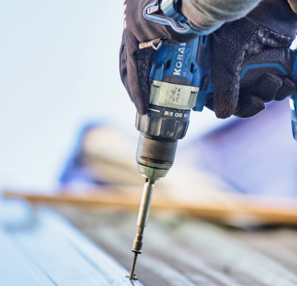 a person using a drill to drill a piece of wood