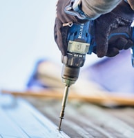 a person using a drill to drill a piece of wood