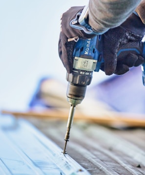 a person using a drill to drill a piece of wood