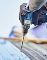 a person using a drill to drill a piece of wood