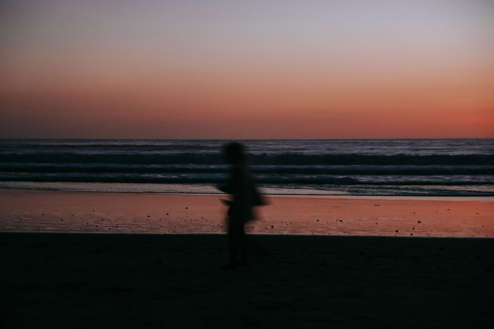 a blurry photo of a person walking on a beach