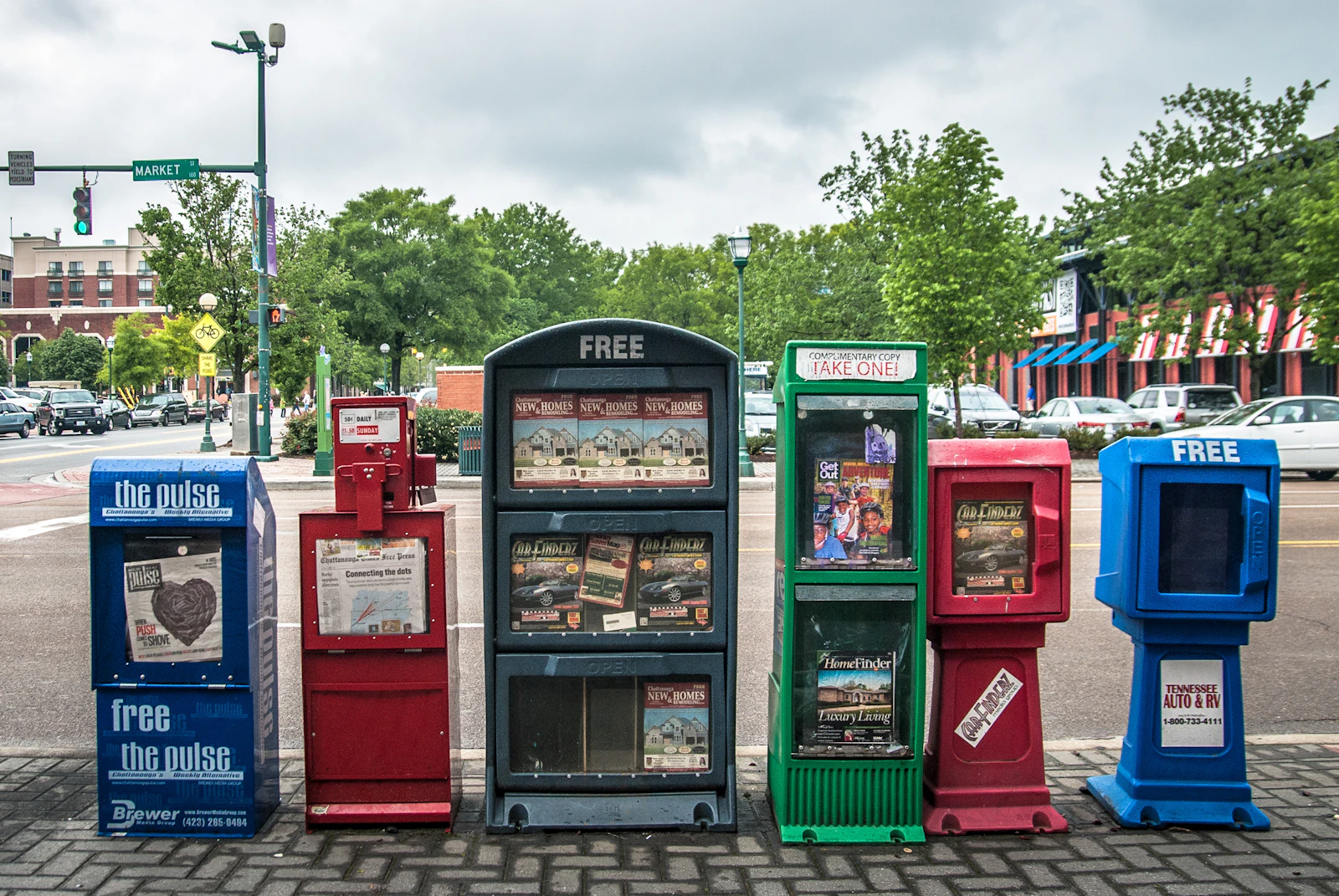 Row of local newspaper boxes on a street, representing regional press backlinks that hold value in the US, UK, Canada and Australia