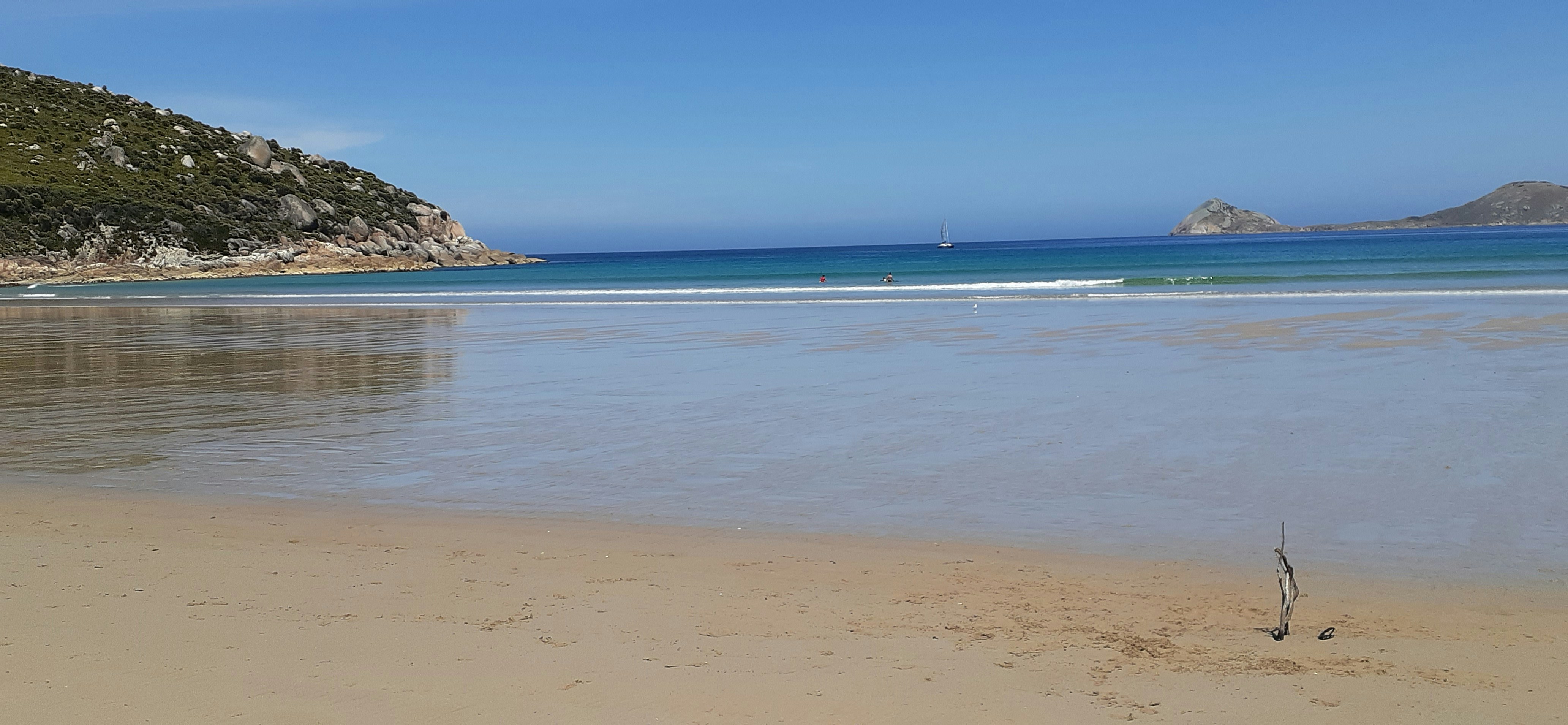 a sandy beach next to a body of water