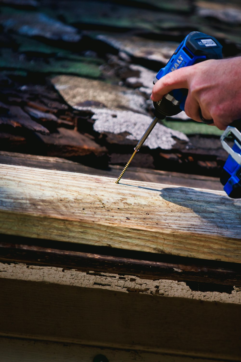a person using a screwdriver on a piece of wood