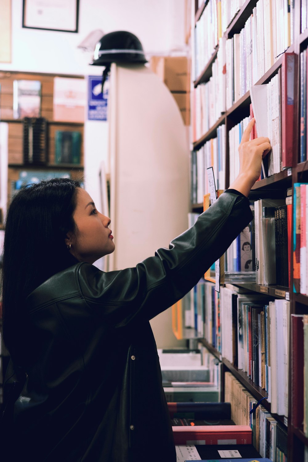 a woman is looking at books on a shelf