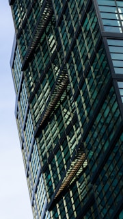A stunning modern building with glass facade and greenery.