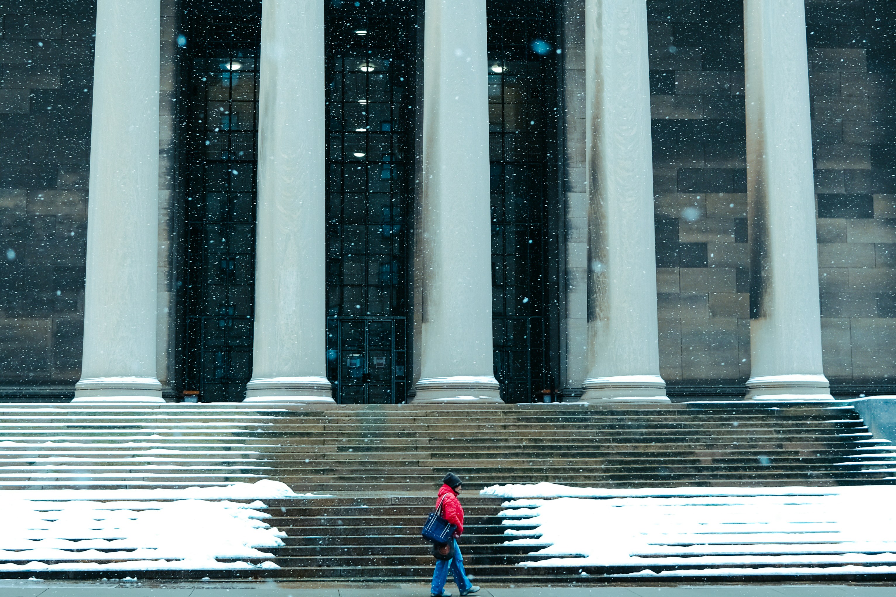 Due persone che camminano nella neve davanti a un edificio