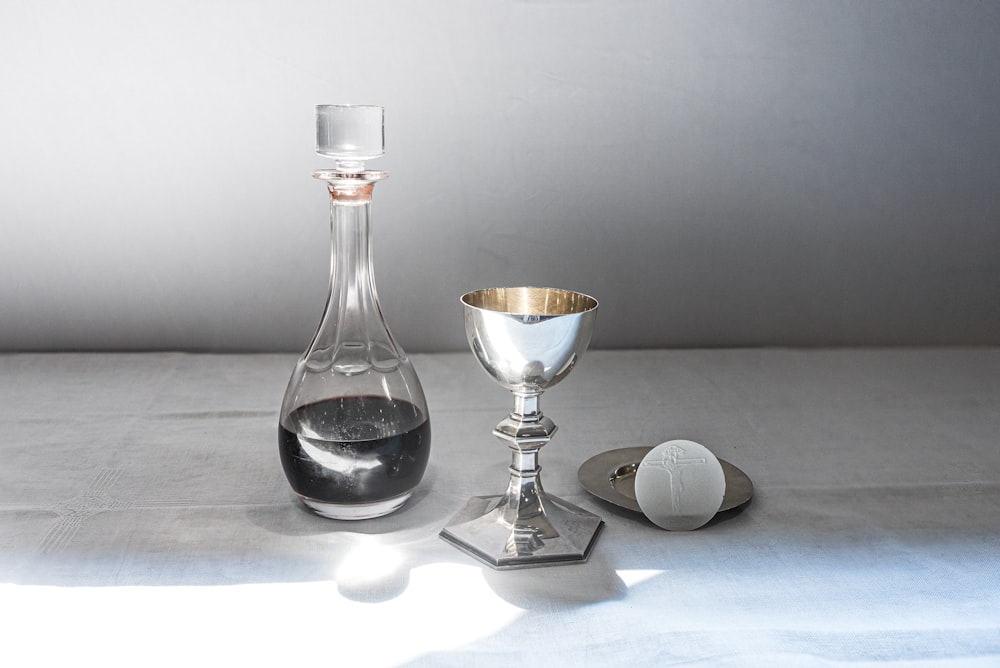 a wine decanter, a goblet and a wine glass on a