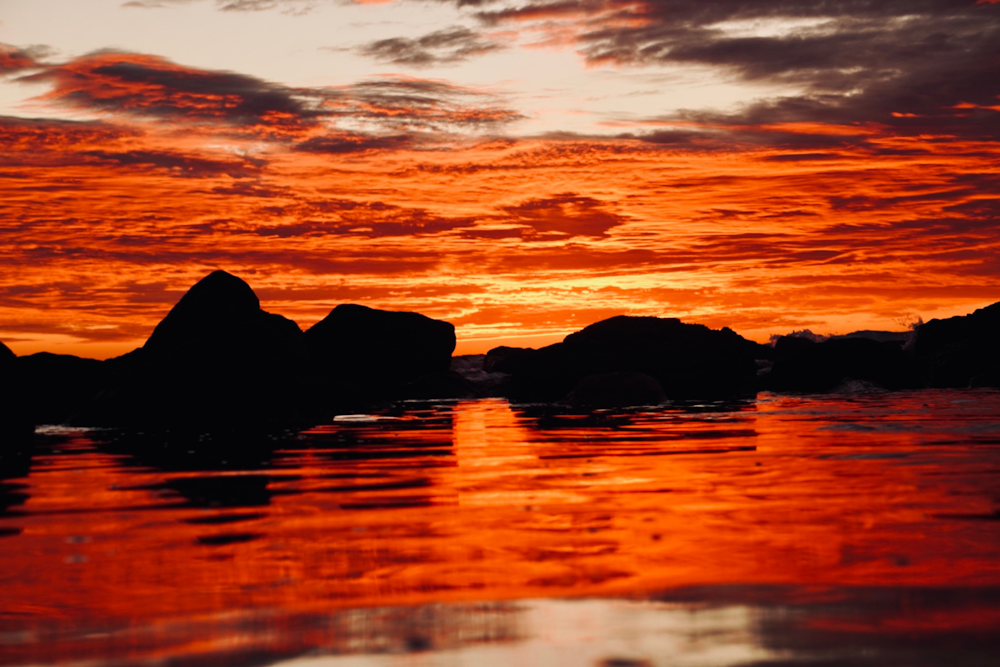 un cielo rosso con nuvole riflesse nell'acqua