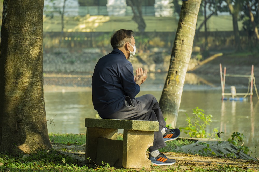 Ein Mann sitzt auf einer Bank in einem Park