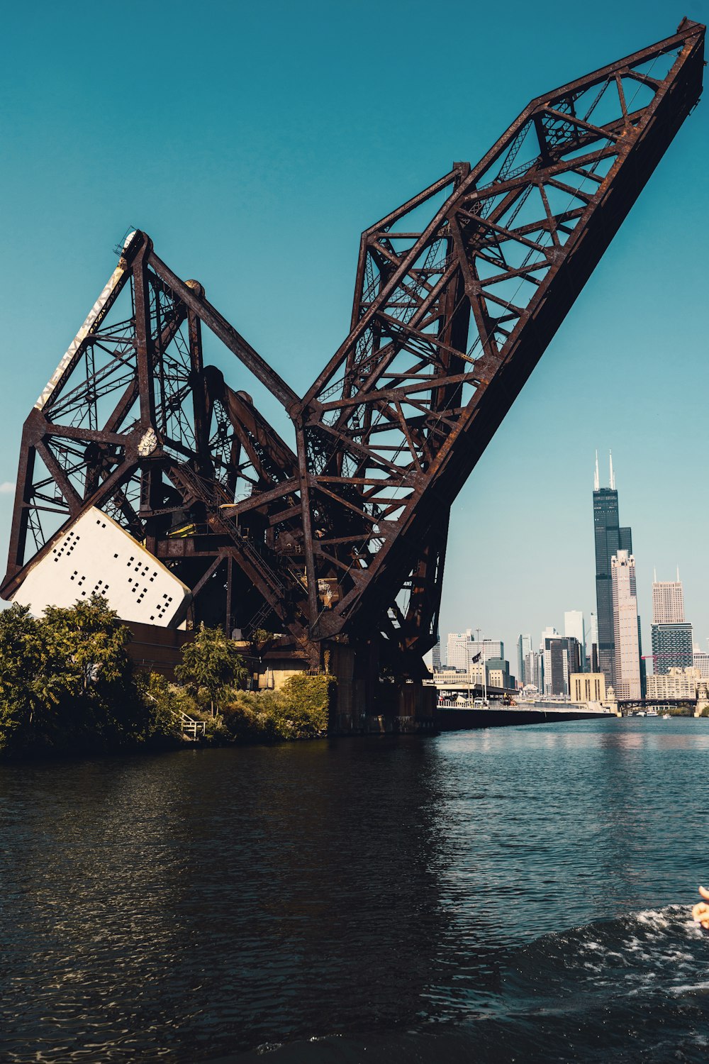 a boat traveling down a river next to a bridge