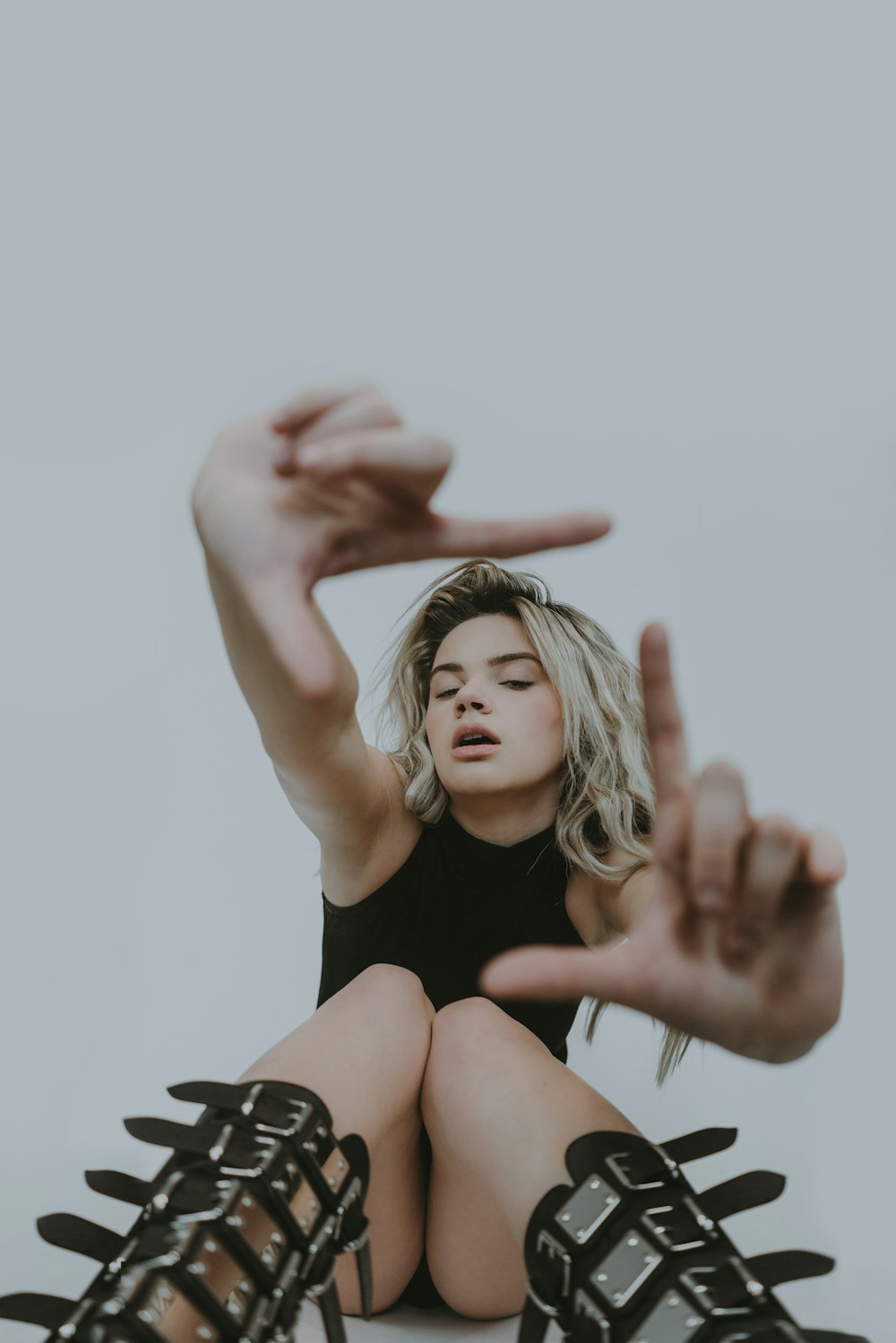 a woman sitting on the ground with her hands in the air