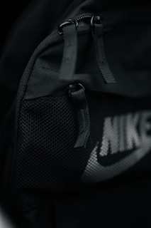 a black nike backpack with a white nike logo on it