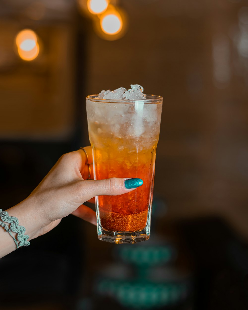 a person holding a glass with ice in it