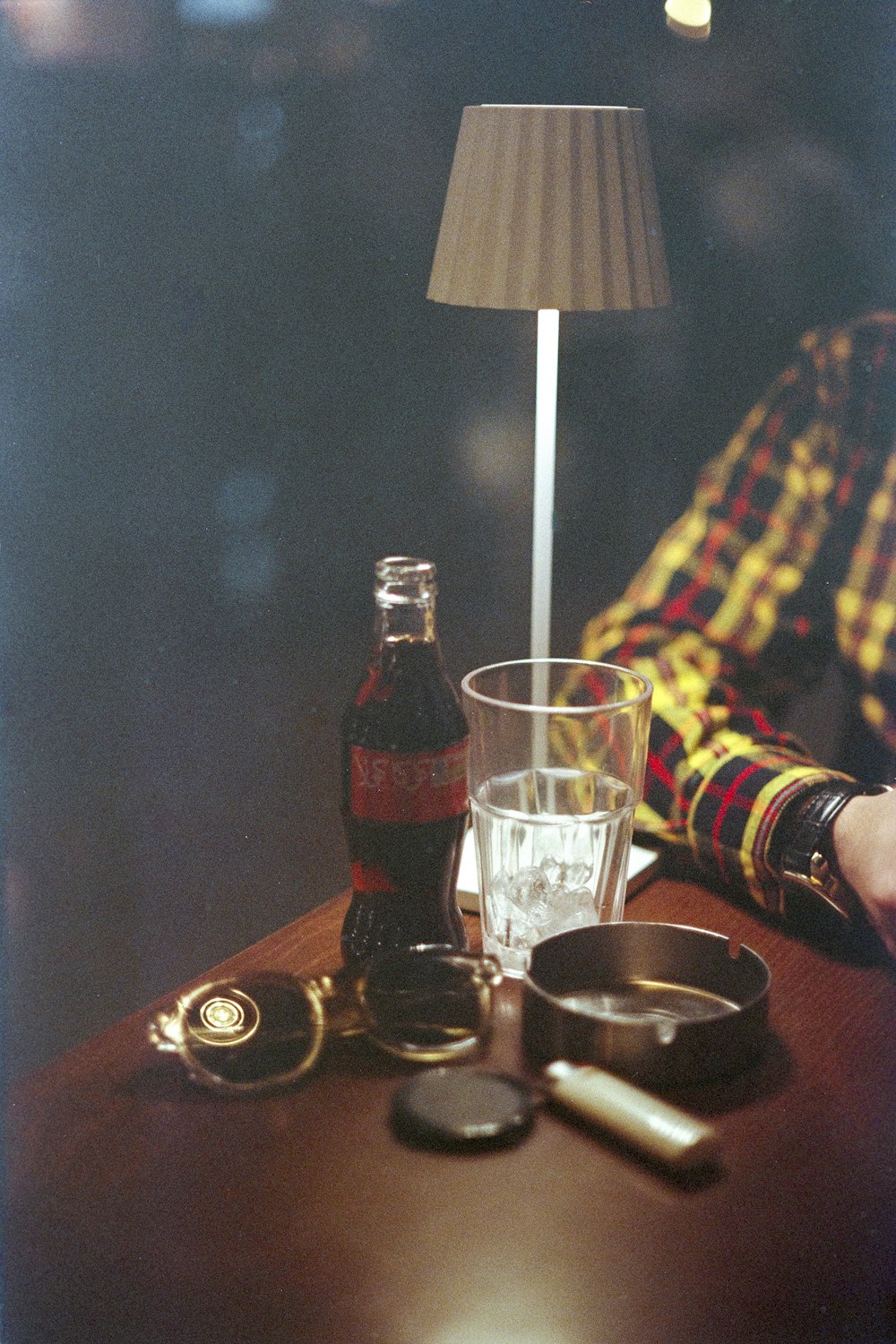 une personne assise à une table avec une bouteille d’alcool