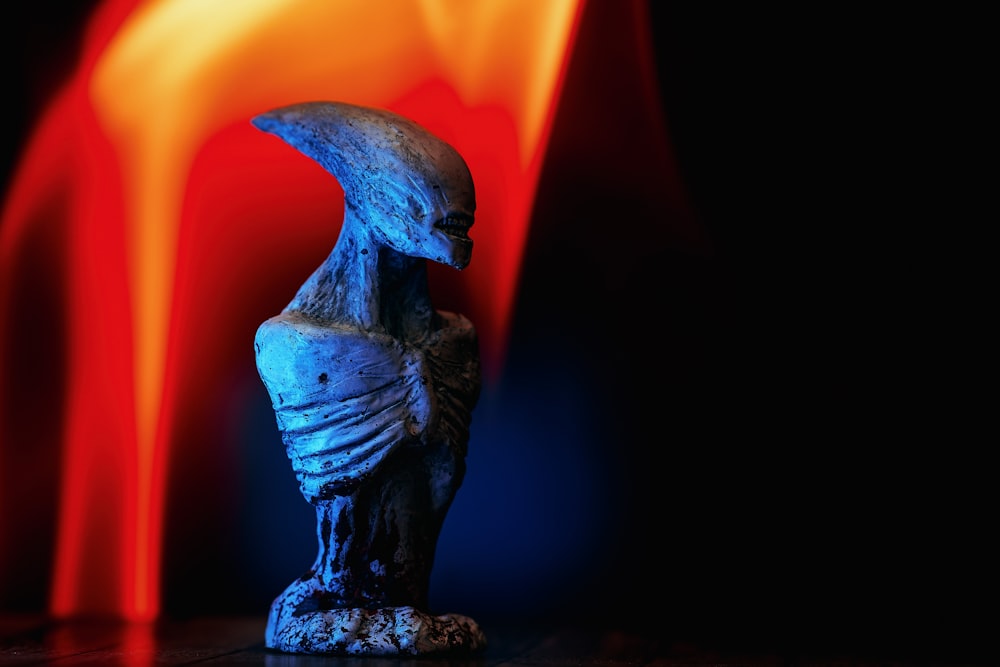 a statue of an alien sitting on top of a table