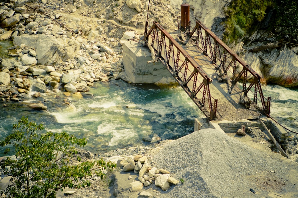 a bridge over a river that is surrounded by rocks