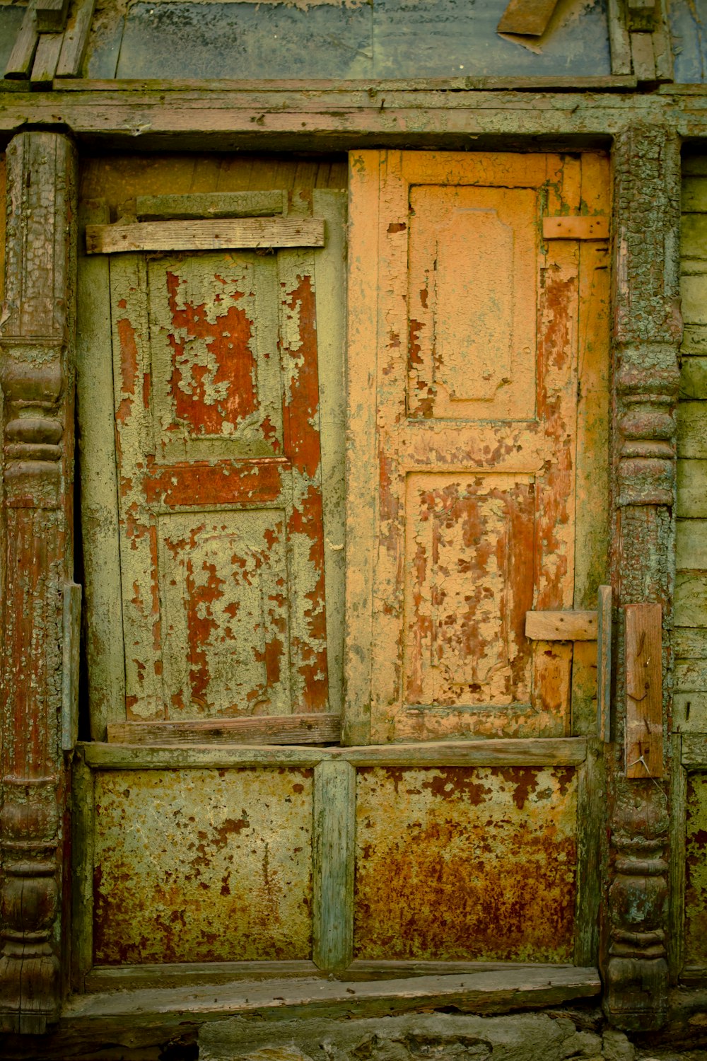 an old wooden door with peeling paint on it
