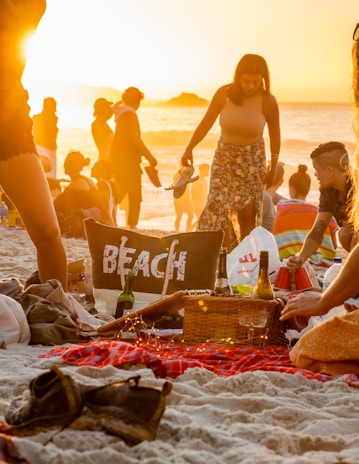 a group of people sitting on top of a sandy beach