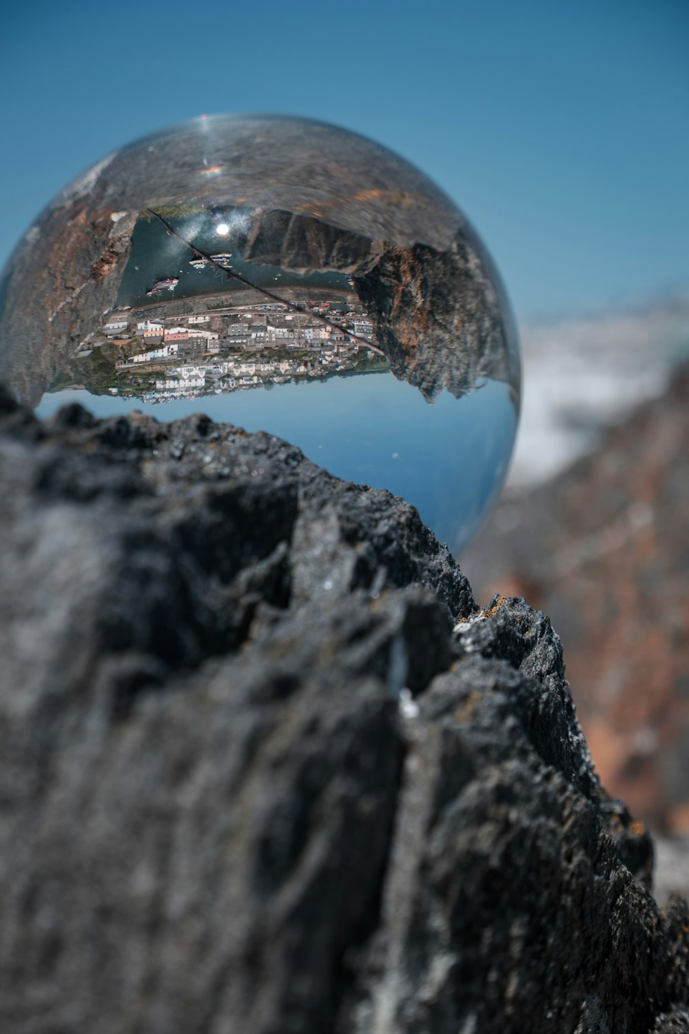 a glass ball sitting on top of a rock