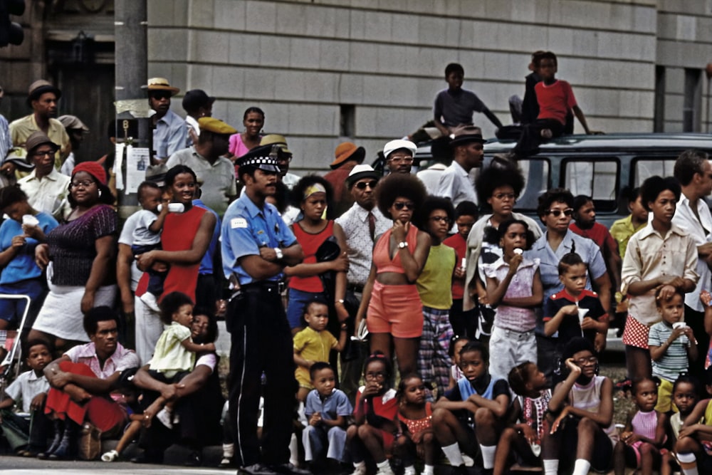 a group of people standing on the side of a road