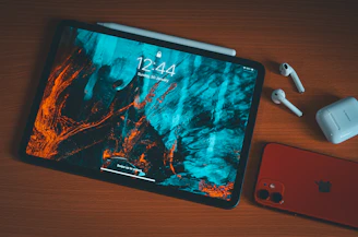 an apple tablet with headphones and an iphone