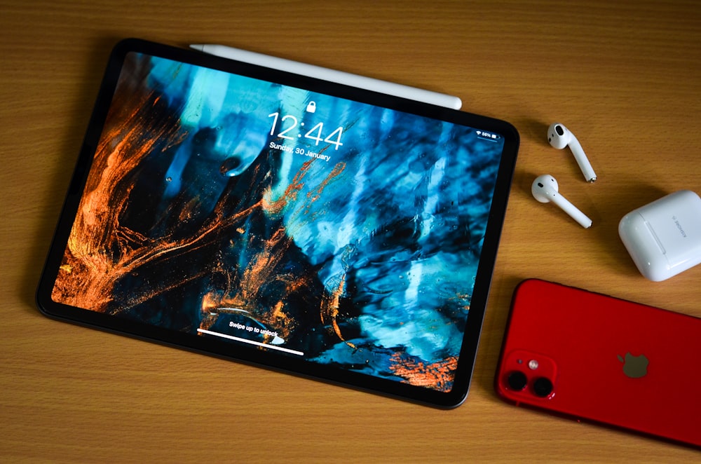 a tablet with a picture on it next to a red phone