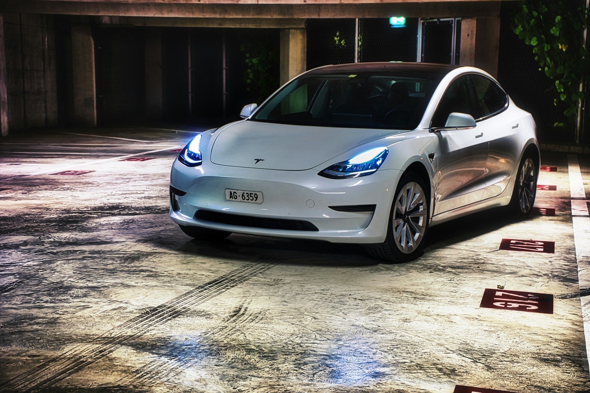 a white electric car parked in a parking lot