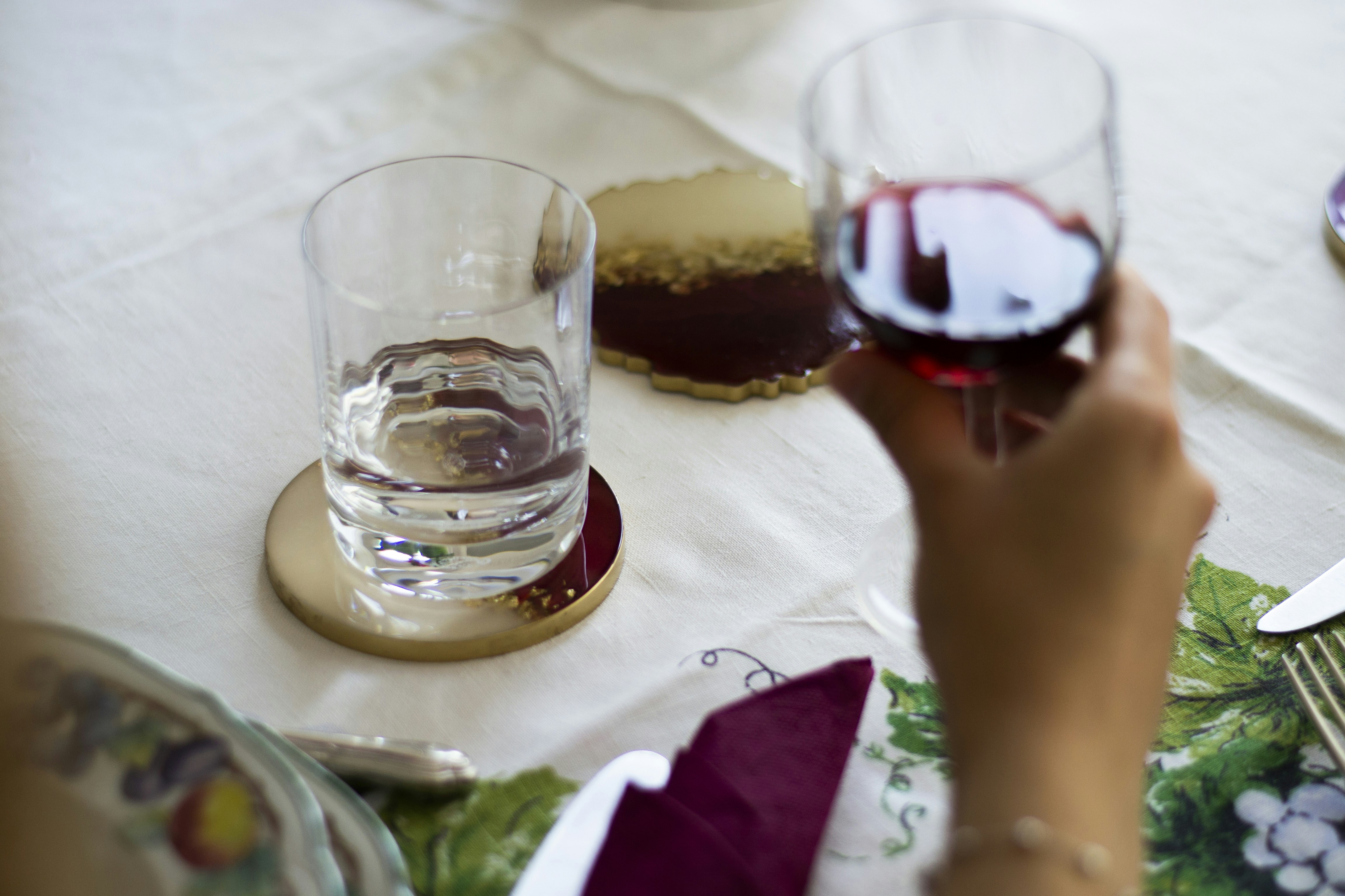 a person holding a glass of wine on a table