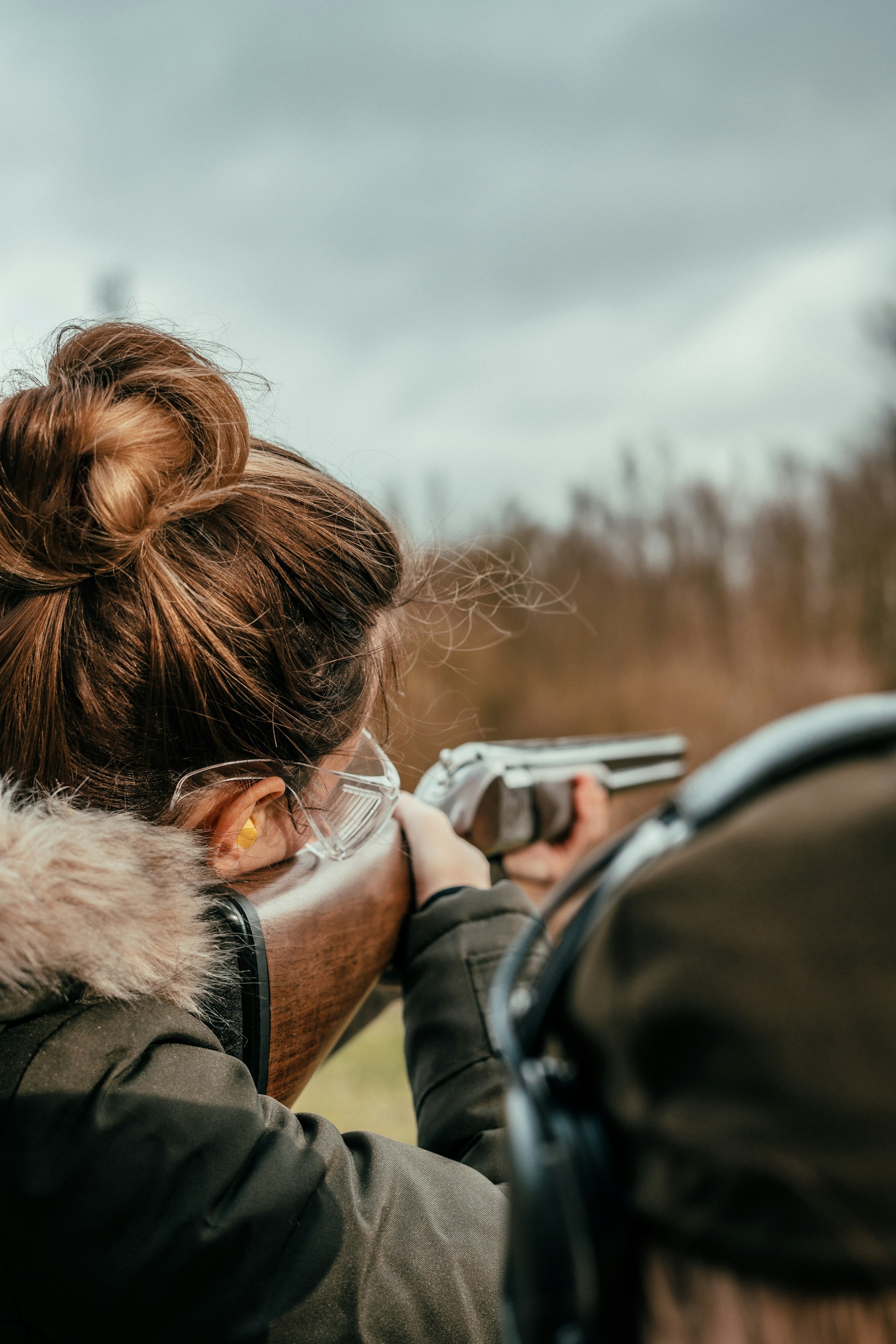 a woman aiming a rifle at a target