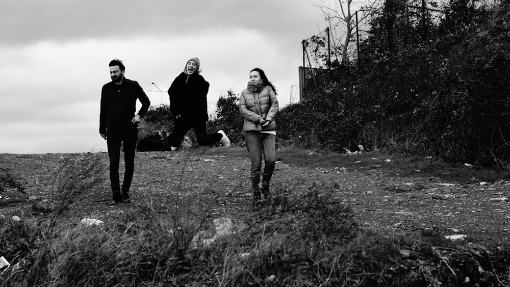 a group of people standing on top of a grass covered field