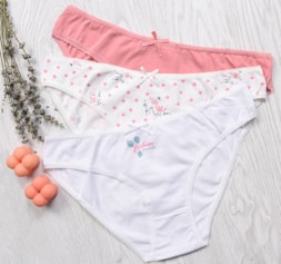 three women's underwear on a white wooden surface