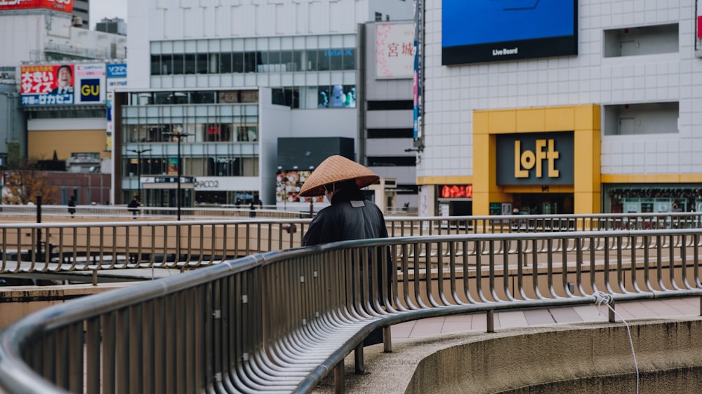 a person sitting on a bench with a hat on