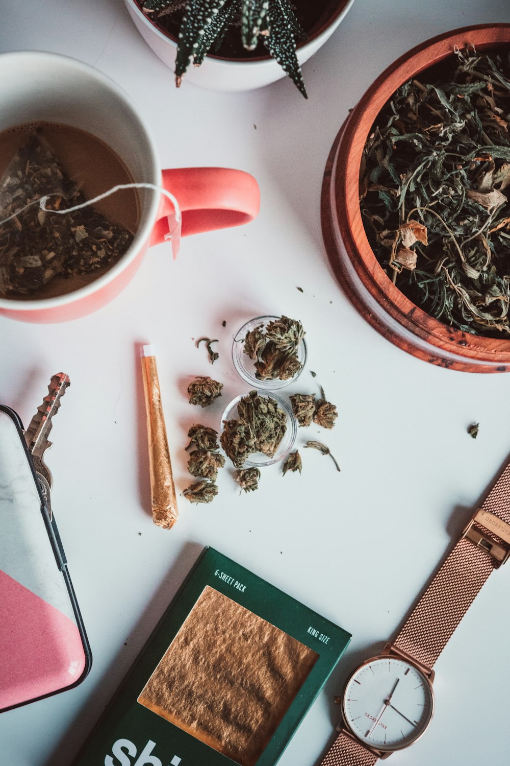 a cup of tea next to a clock and a cigarette