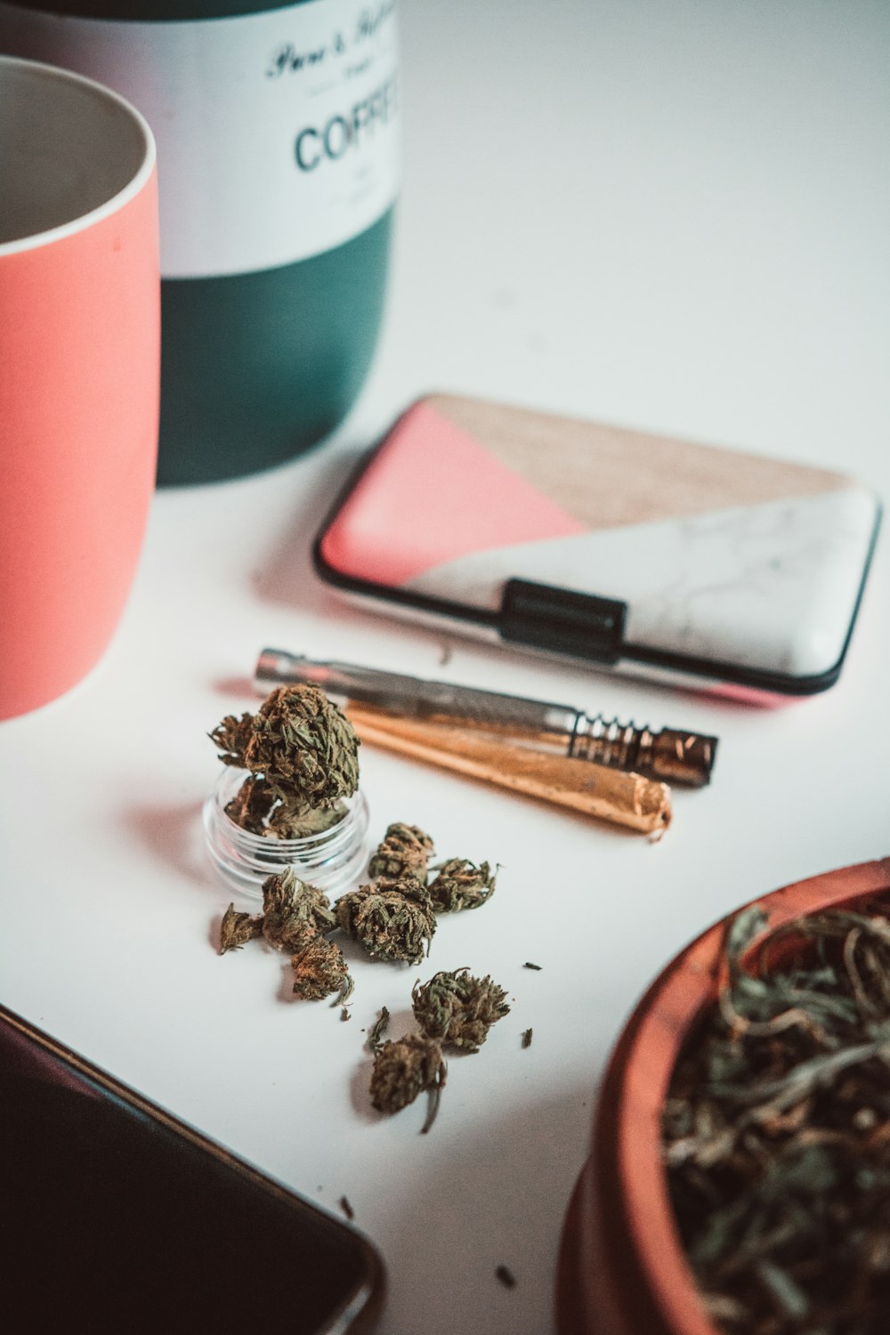 a cup of coffee, a cigarette, and some other items on a table