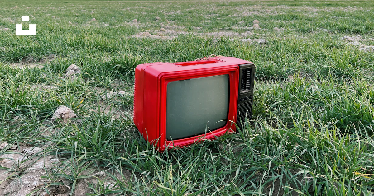 Une télévision rouge assise au milieu d’un champ photo – Photo 감시 장치 ...