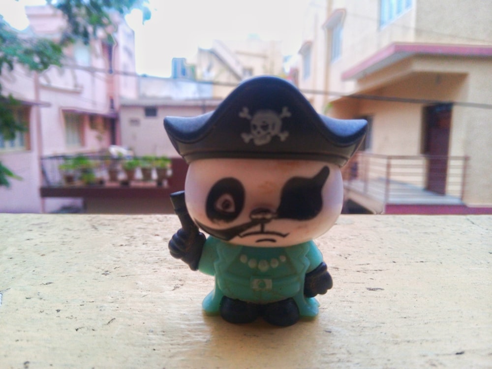 une petite figurine d’un chat portant un chapeau de pirate