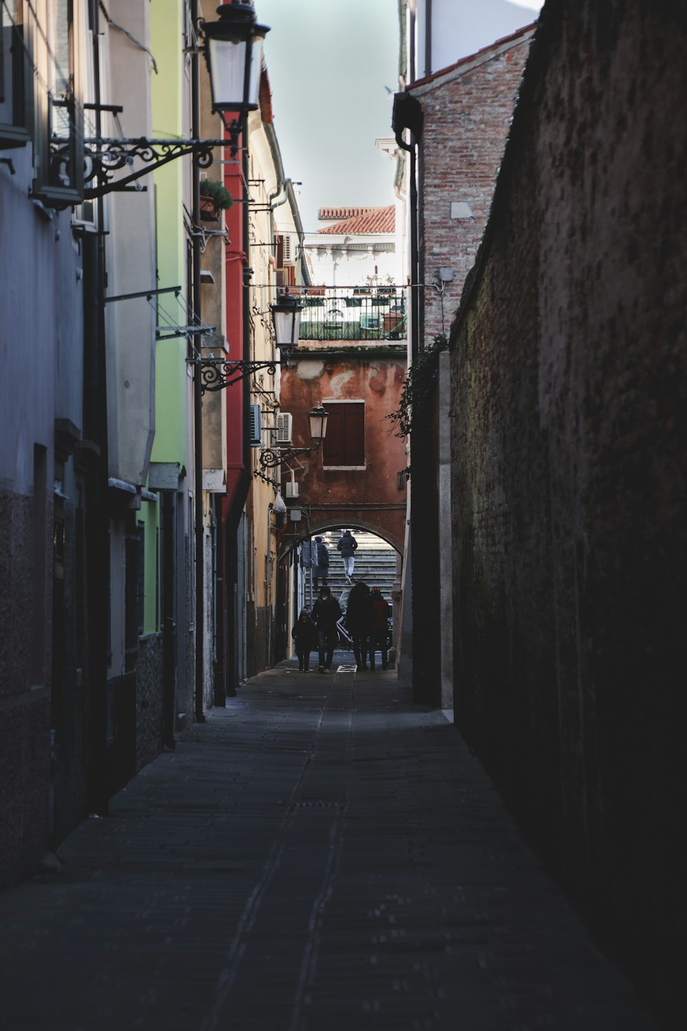 a narrow alley way with people walking down it