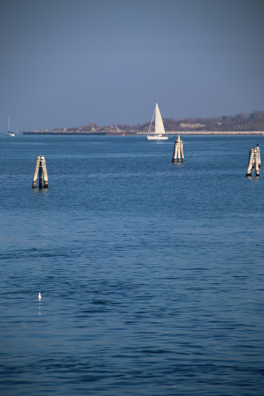 a body of water with a sailboat in the distance