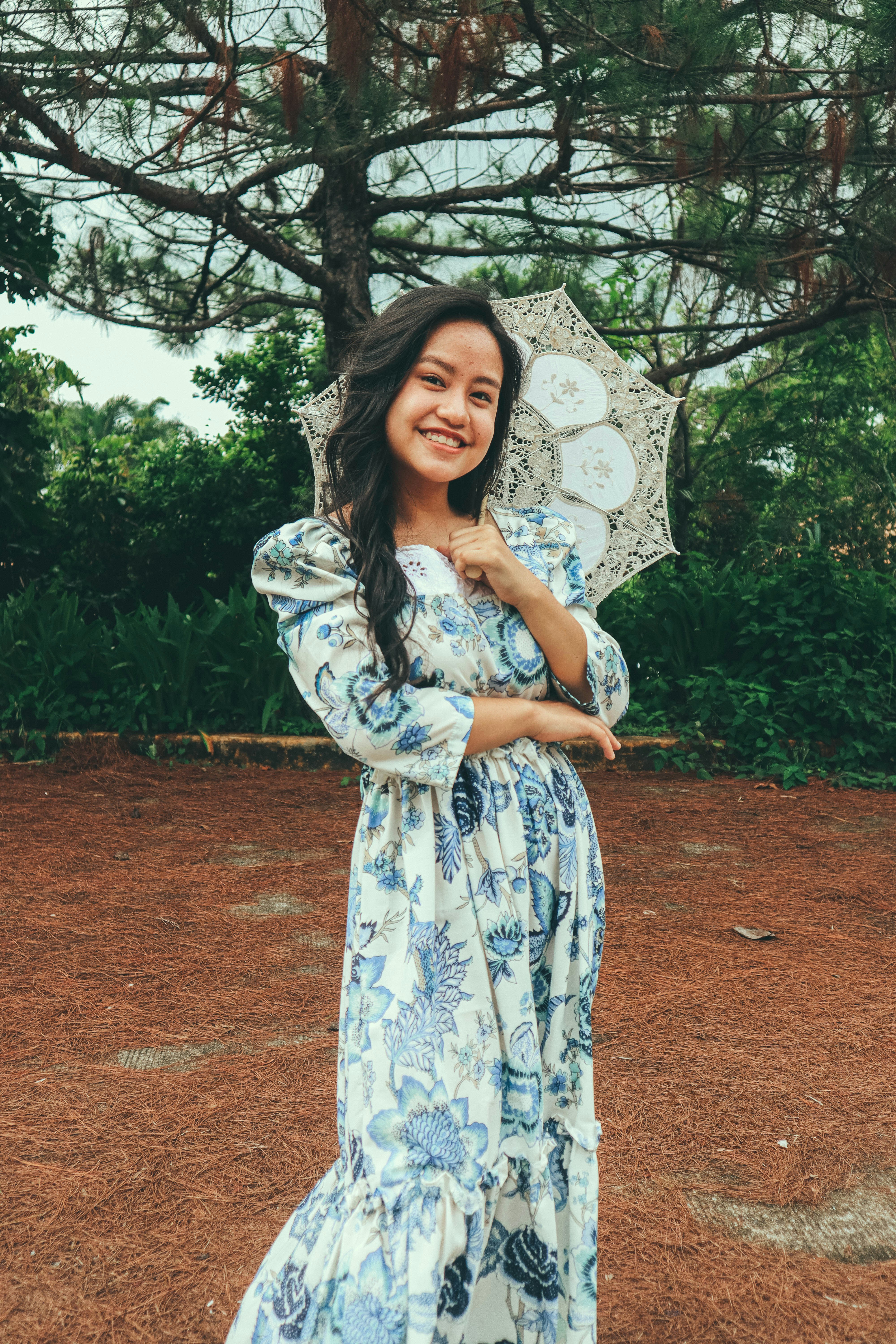 a woman in a long dress holding an umbrella