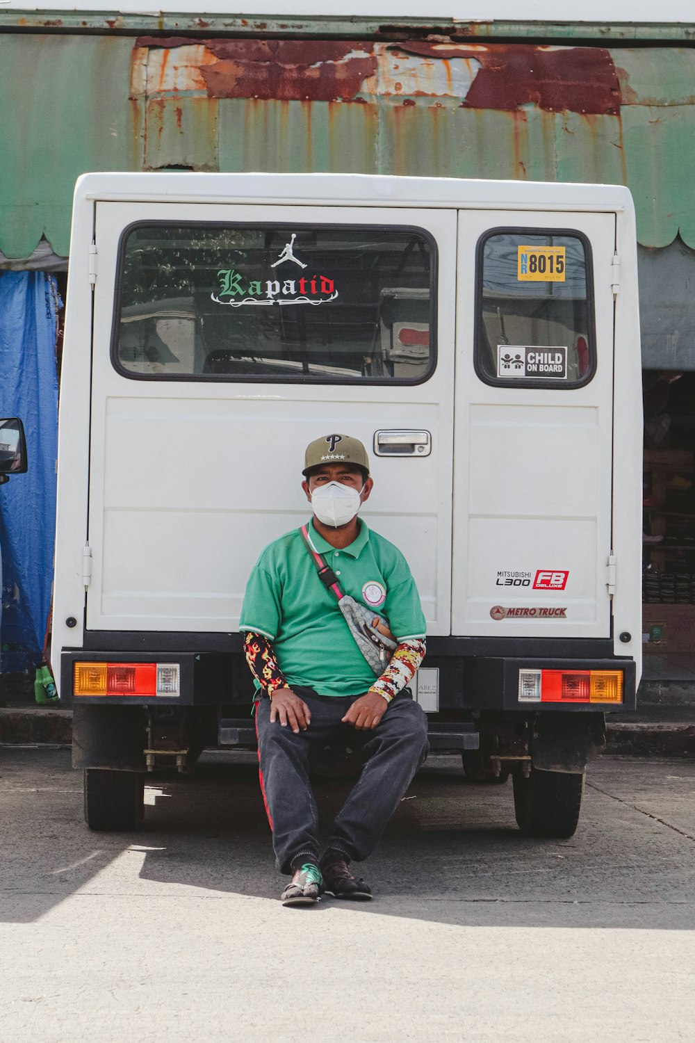 a man sitting on the back of a white truck