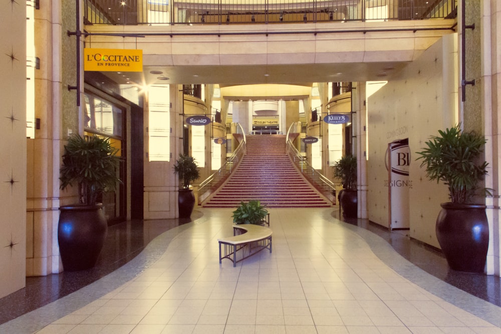 a hotel lobby with a large staircase leading up to the second floor