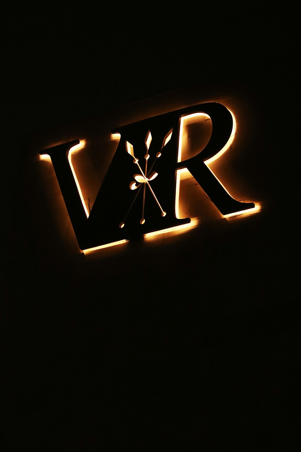 a lighted sign that reads vrr in a dark room