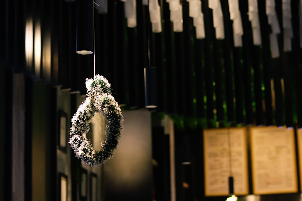 a wreath hanging from a string in front of a pipe