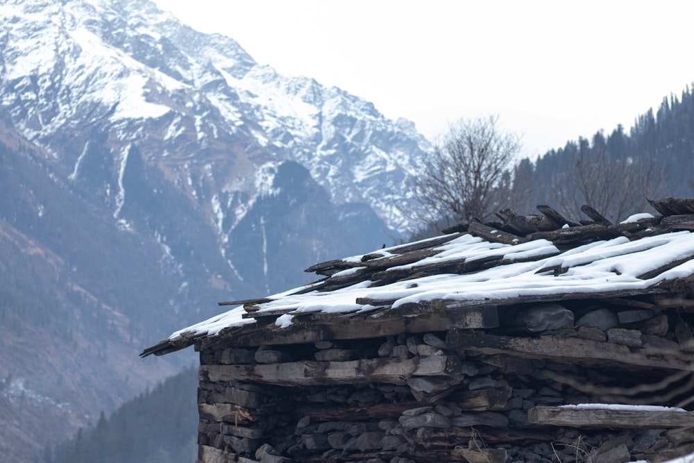 a building with snow on the roof and mountains in the background