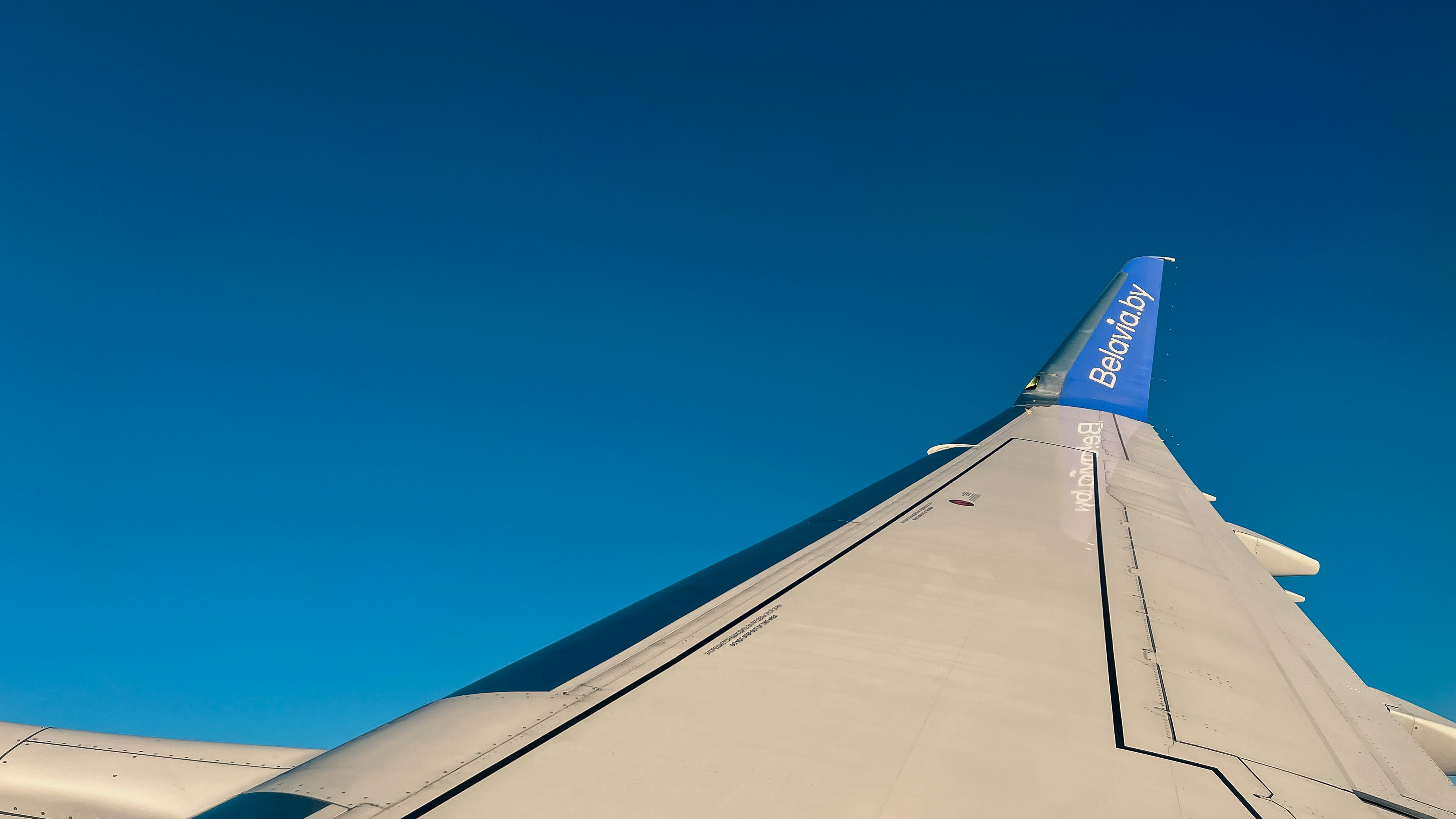 the wing of an airplane against a blue sky