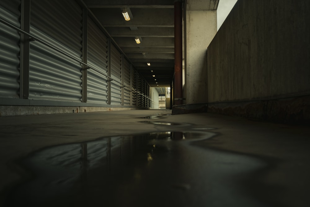 a dark hallway with a puddle of water on the floor