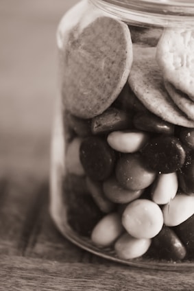 A close-up of a jar filled with assorted premium cookies, showcasing their rich textures and colors.