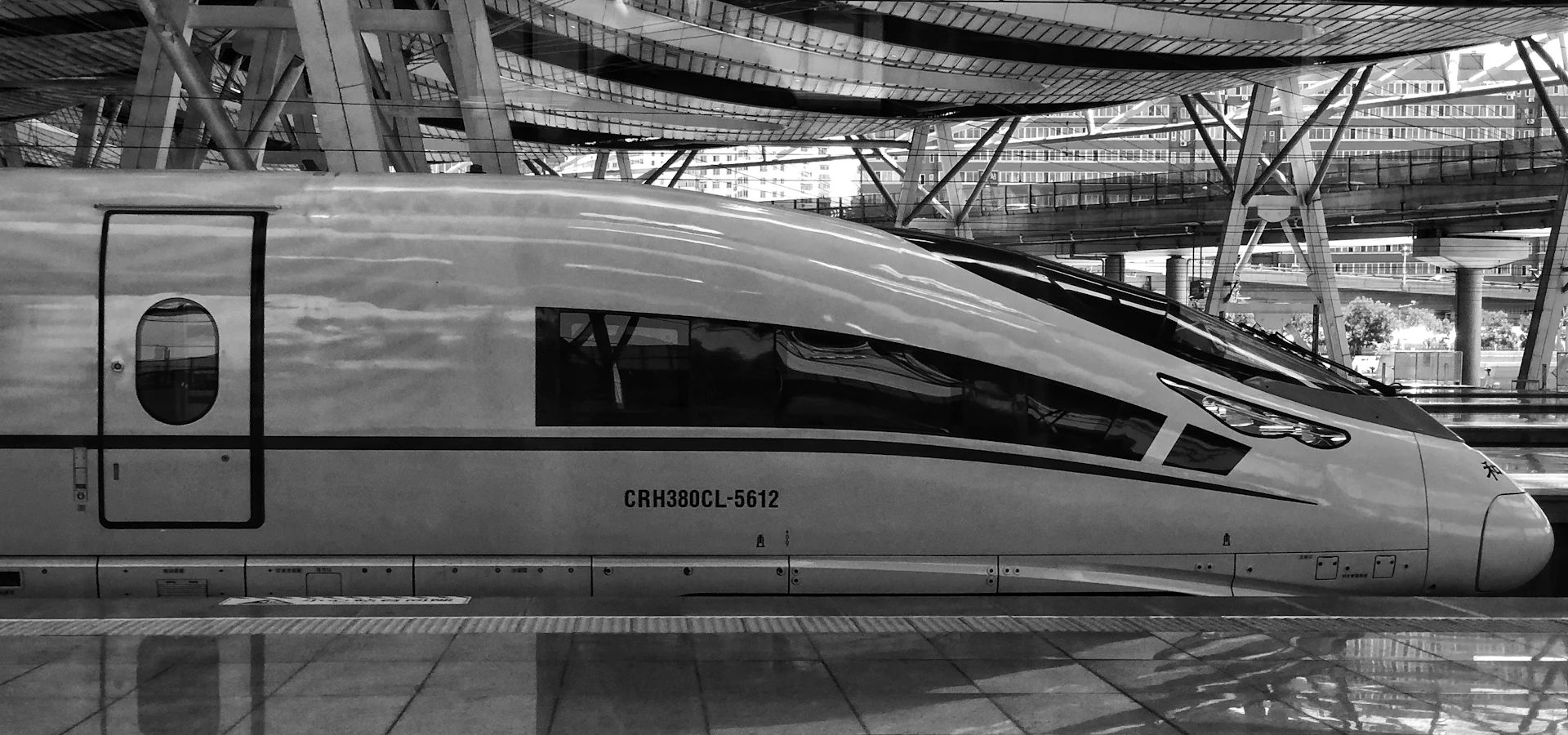 Futuristic design of a sleek Avelina Horizon speed train gliding into a modern station surrounded by smart strip malls and green spaces under a clear sky.